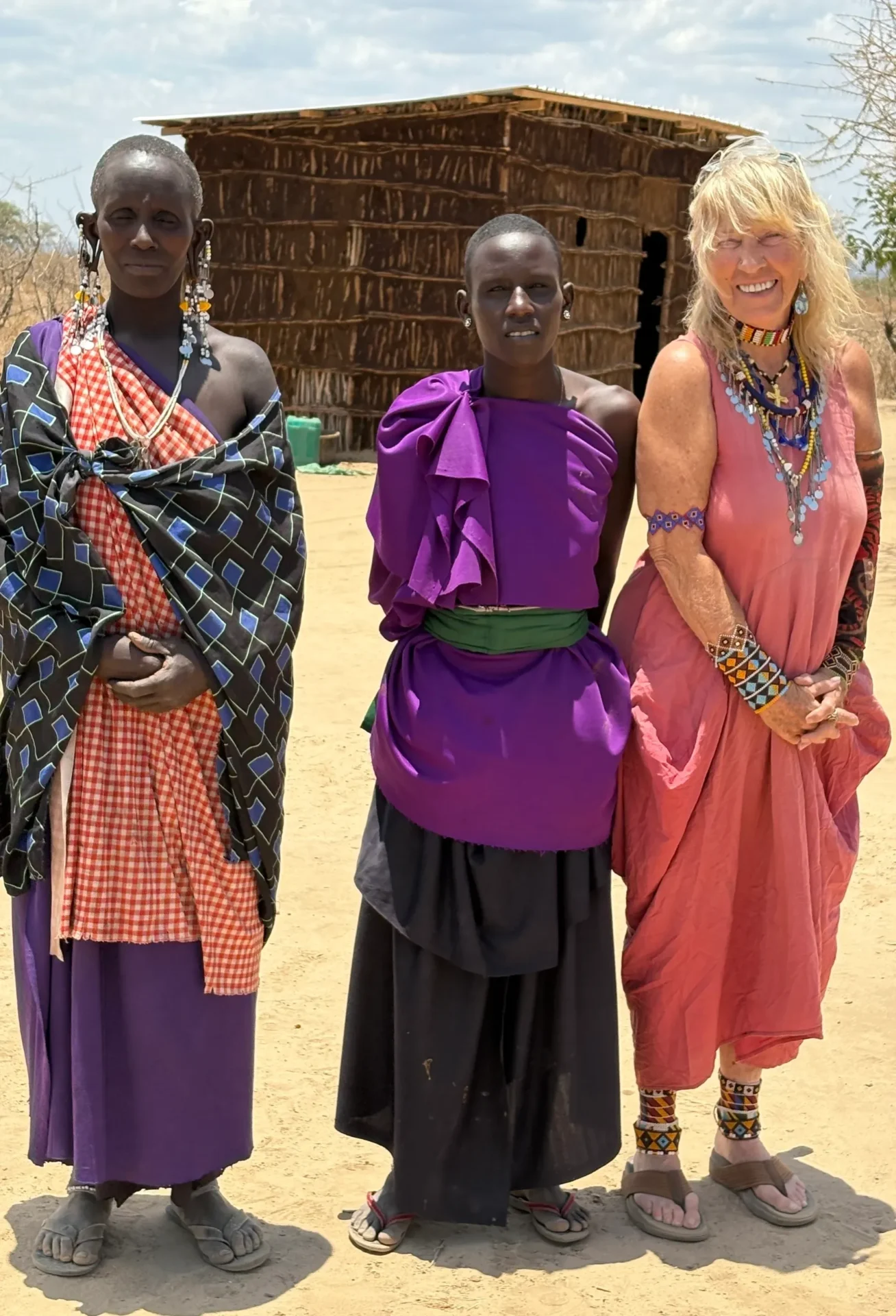 Three people standing in traditional clothing.