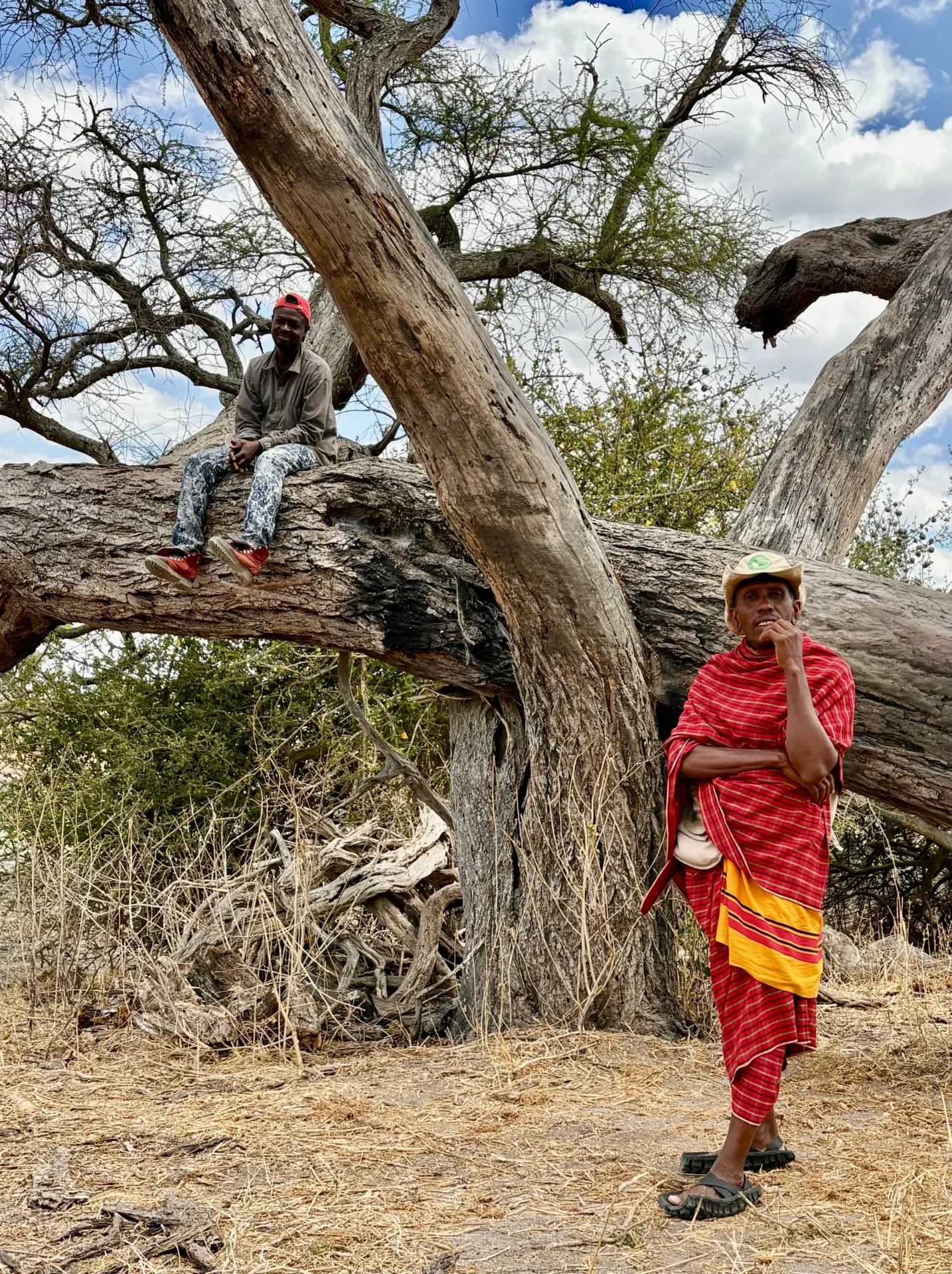 Two people near large tree outdoors.
