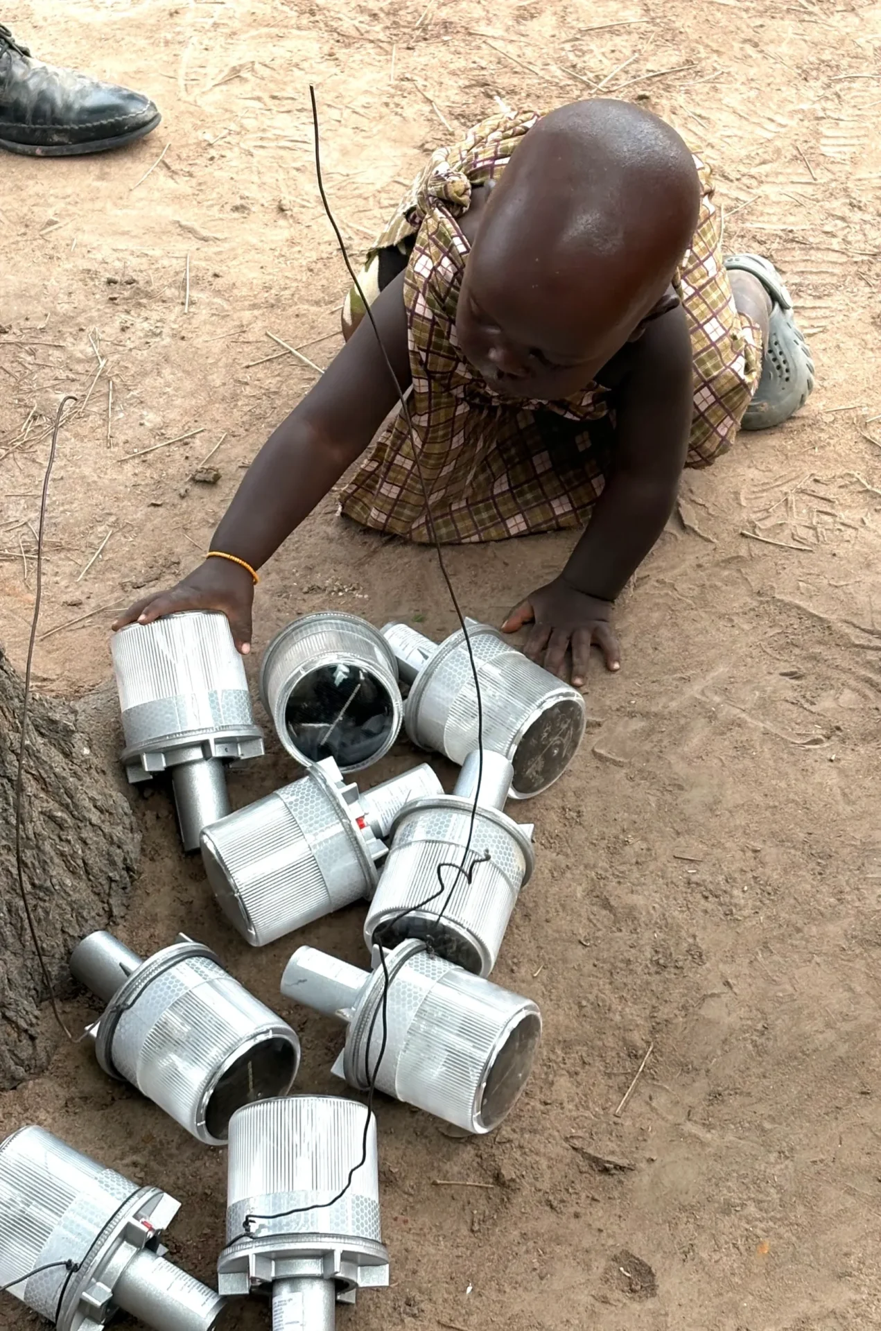 Child playing with solar lights on ground.