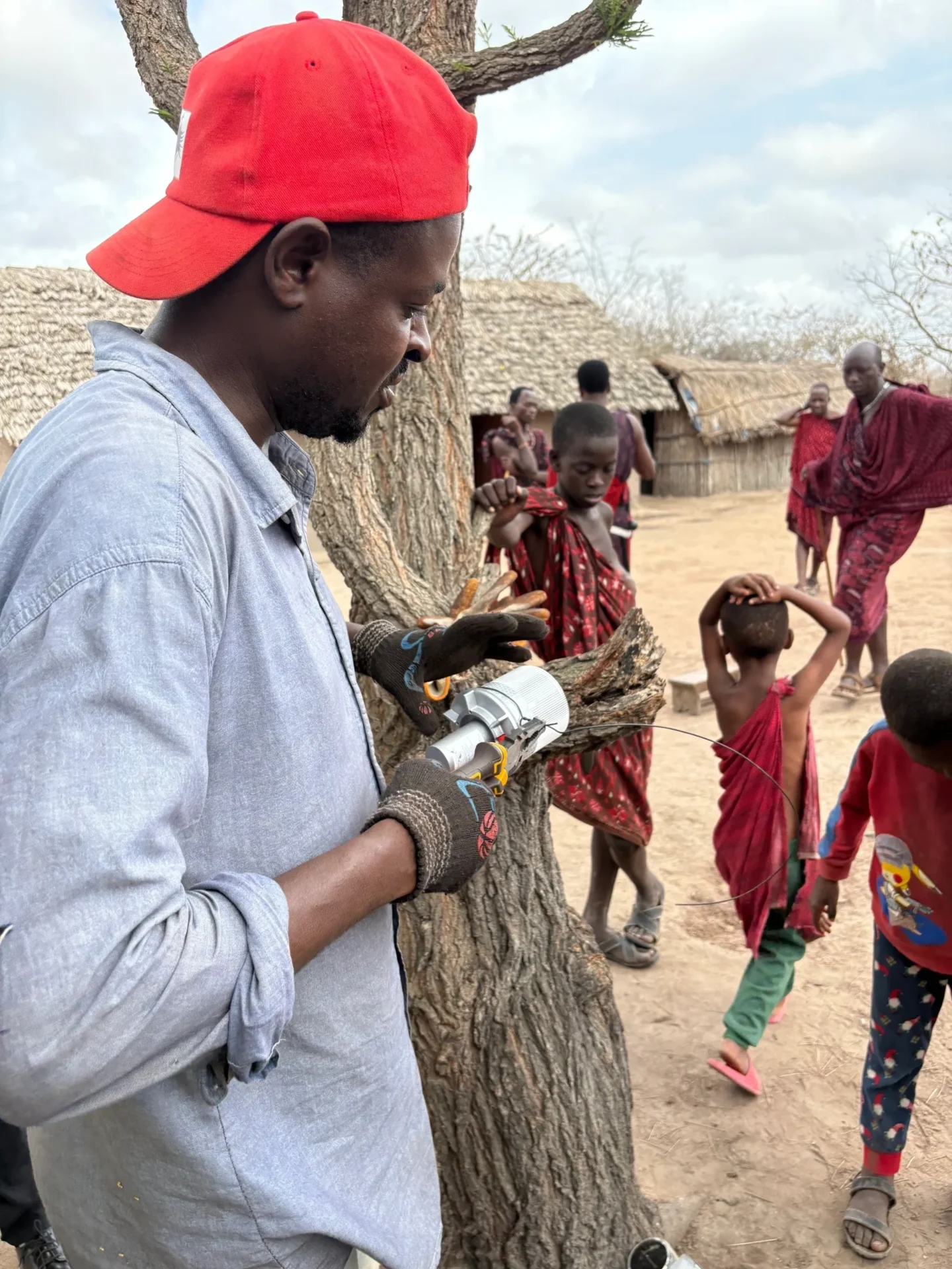 Man working near children in rural area.