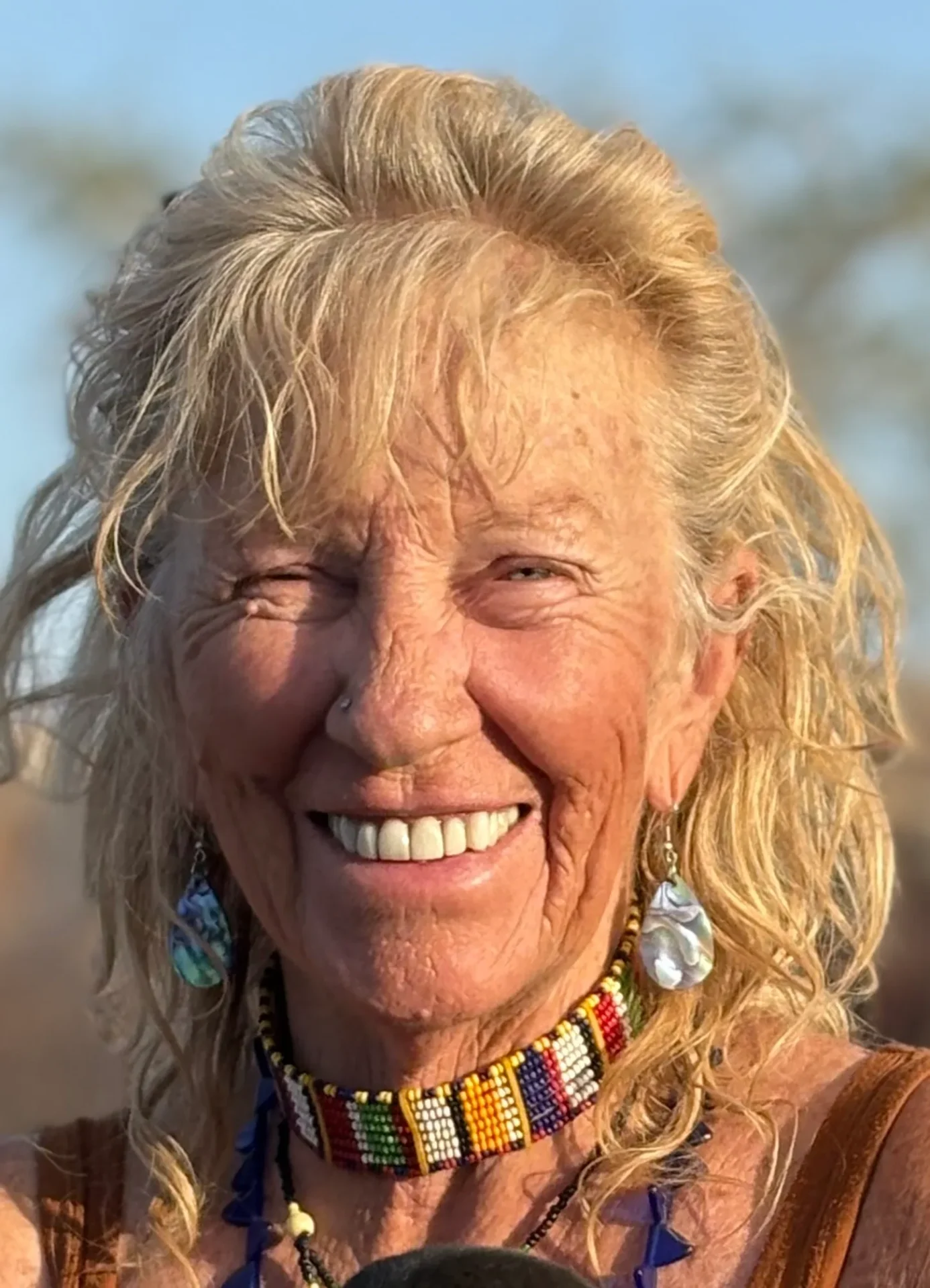Smiling woman with colorful beaded necklace.