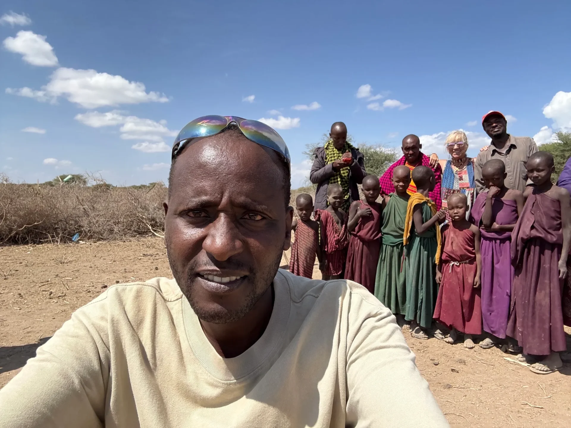 Group of people posing in sunny landscape.