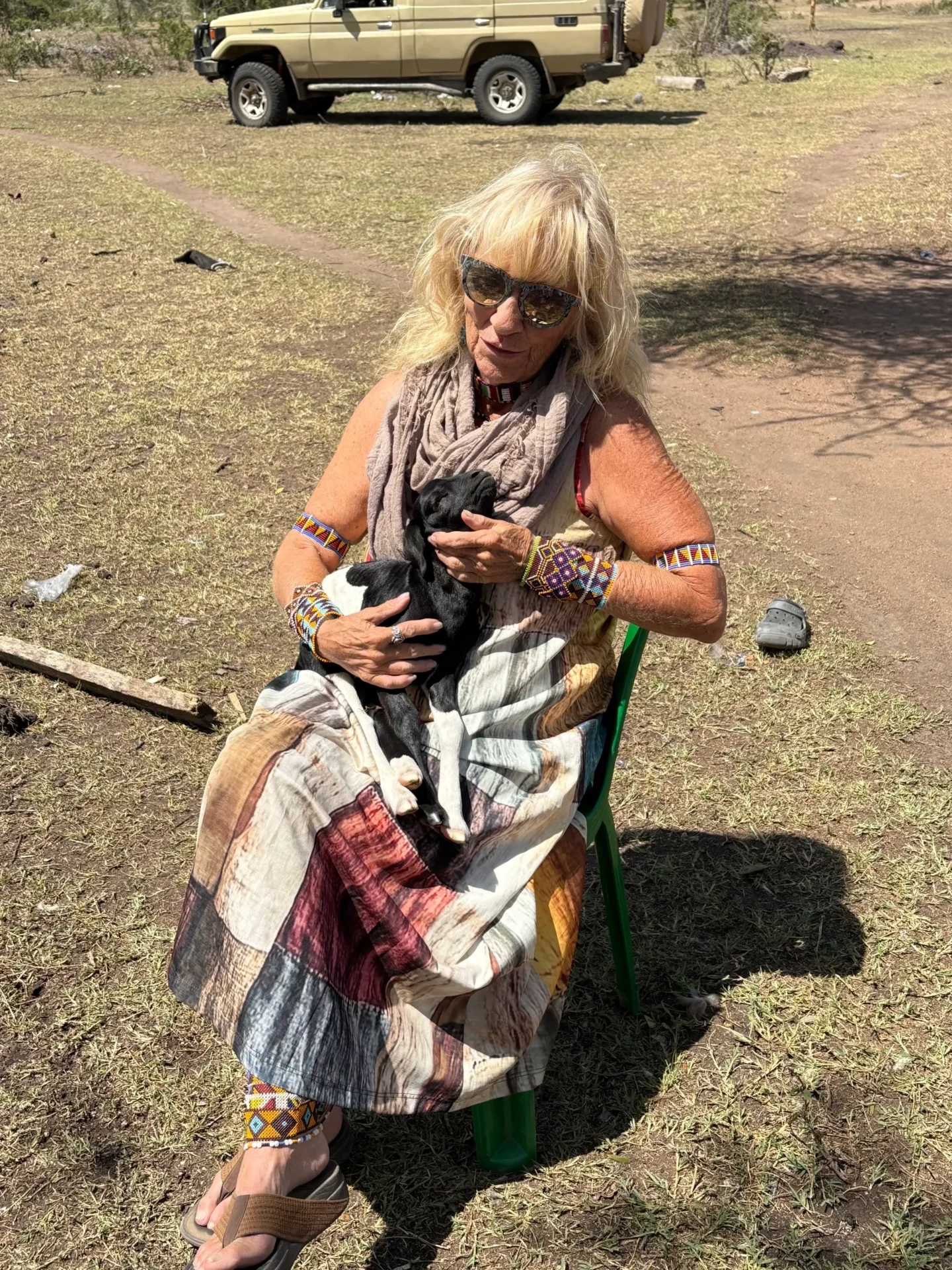 Woman holding a puppy in outdoor setting.